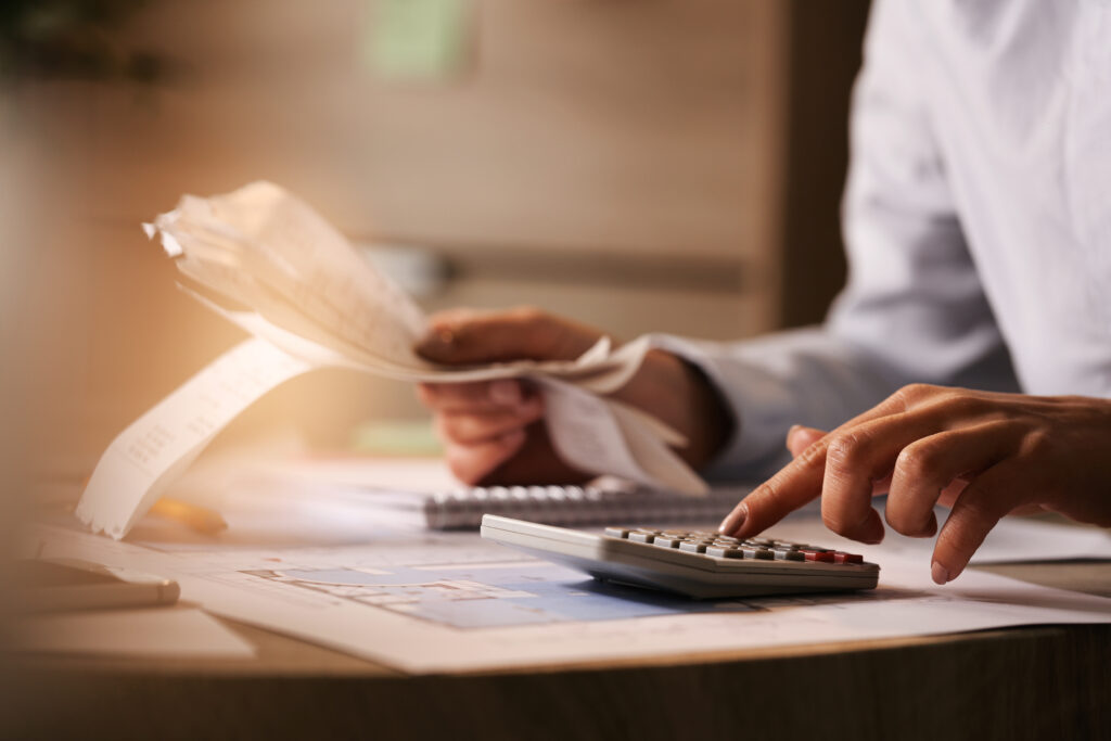 O número de inadimplentes no país se manteve estável em maio de 2024, repetindo o de abril de 2024 – o maior da série histórica do levantamento. 11 closeup economist using calculator while going through bills taxes office