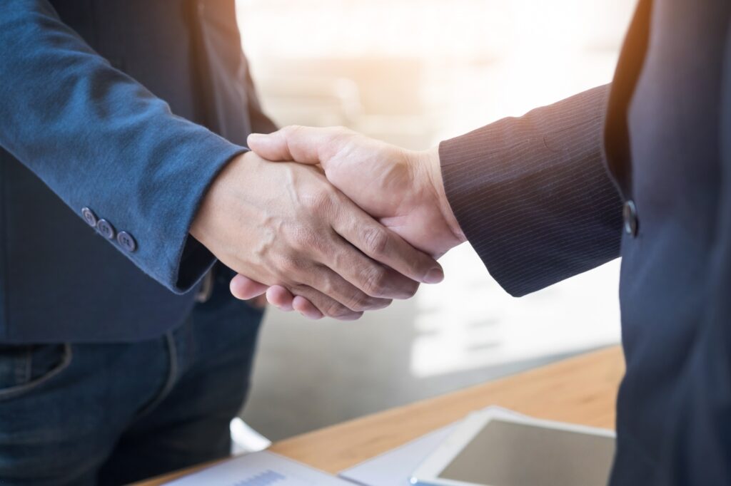 Convênio entre Federação Varejista e concessionária oferece condições especiais na compra de veículos Chevrolet 4 two confident business man shaking hands meeting office success dealing greeting partner concept